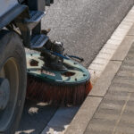 Sweeper truck industrial vehicle cleaning machine cleans urban road the streets of the city. Concept clean city. Street sweeper machine working.